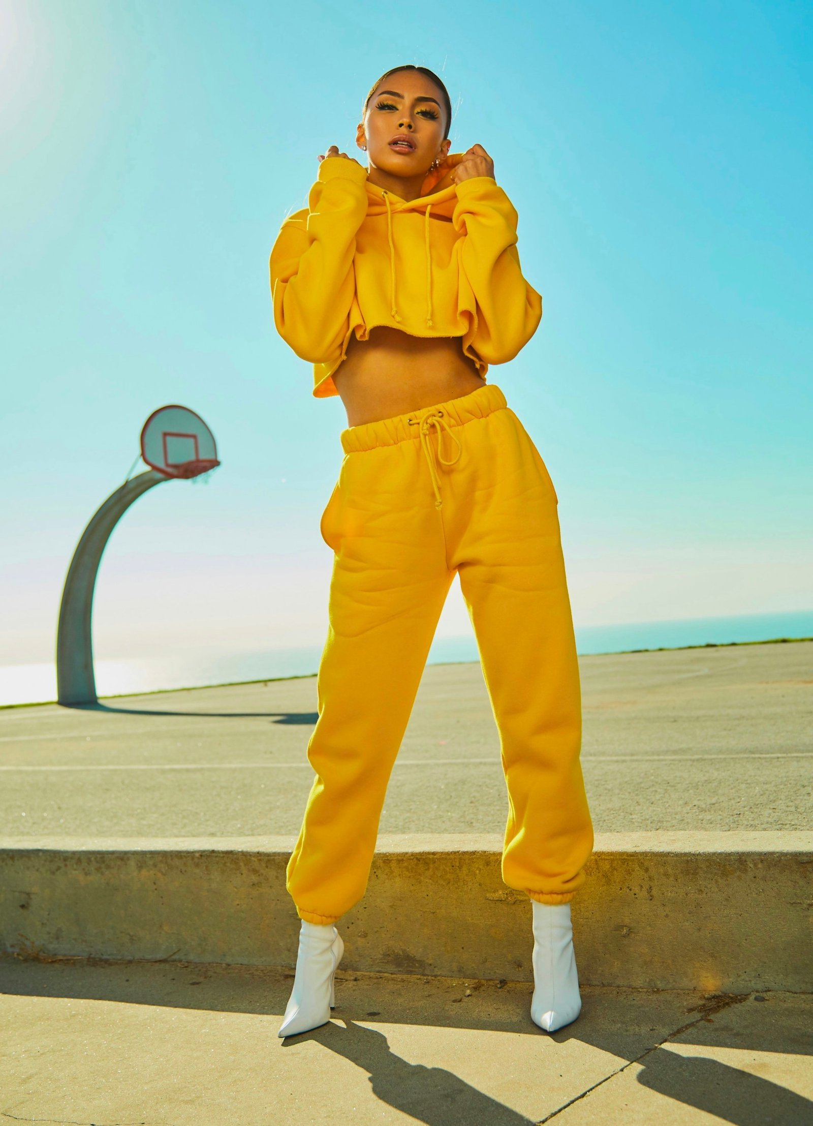 Model wearing a bright yellow hoodie and trousers outdoors